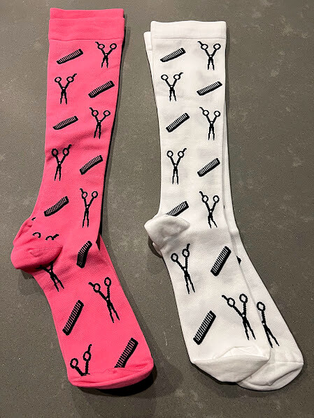 Pink and white Salongevity compression socks side by side showing scissors and comb print