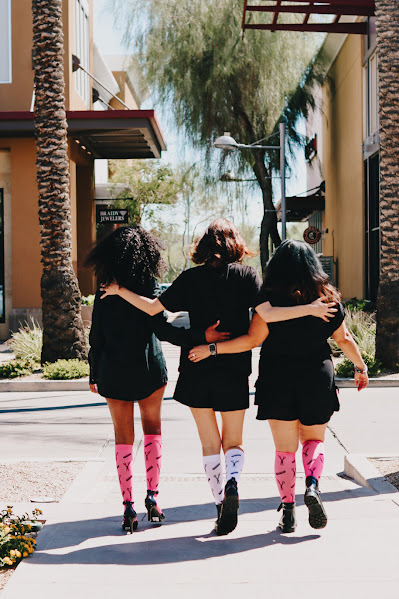 Stylists walking arm in arm wearing compression socks